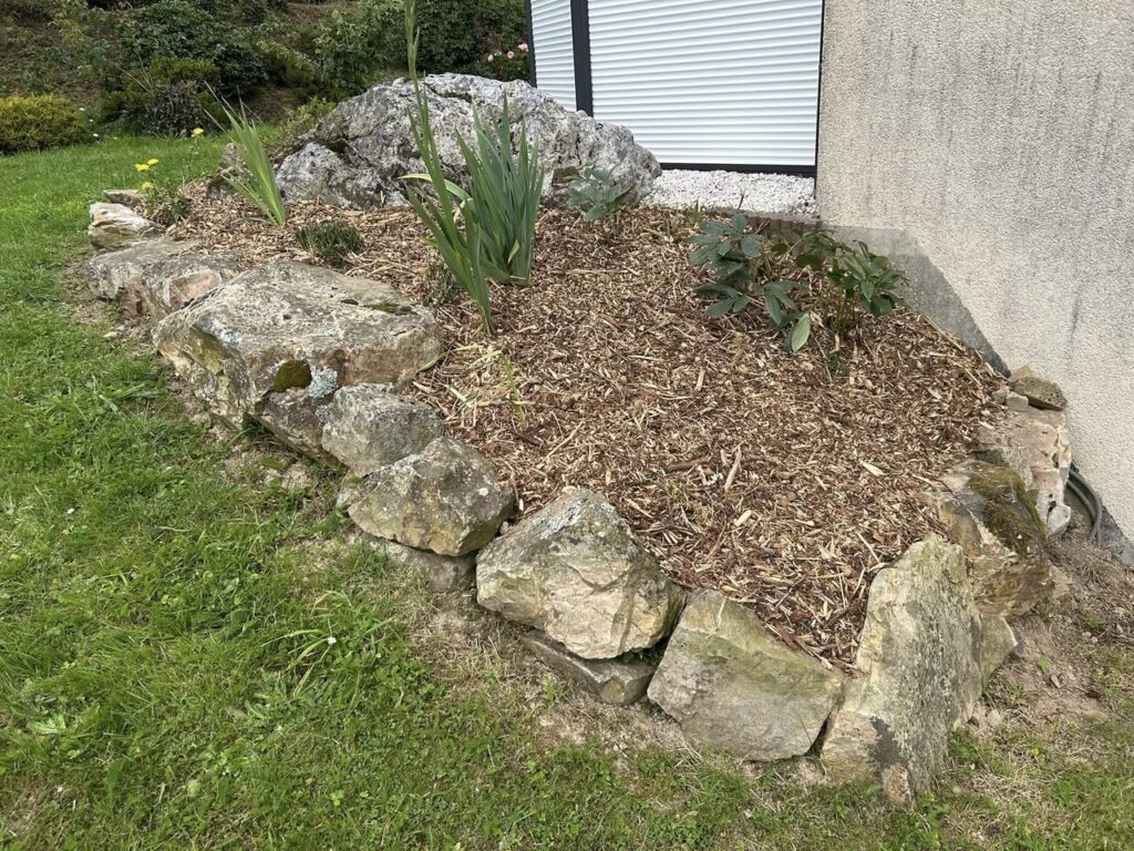 Paillage organique de massif avec bordure de pierres par Paysag & Nous